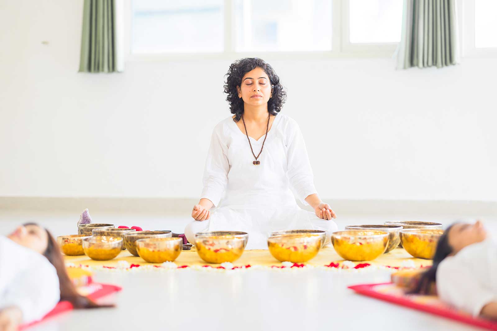 Healer meditating with Tibetan singing bowls for sound healing at Tanmatraa Healing