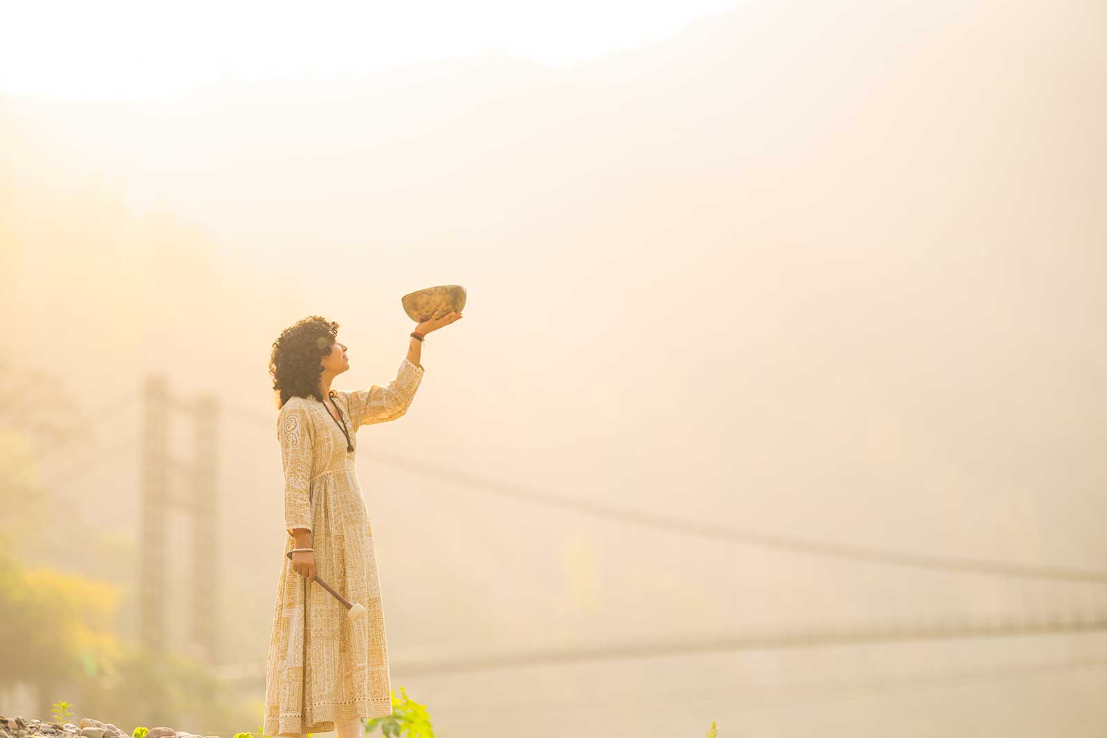 Healer holding a Tibetan singing bowl in sunlight