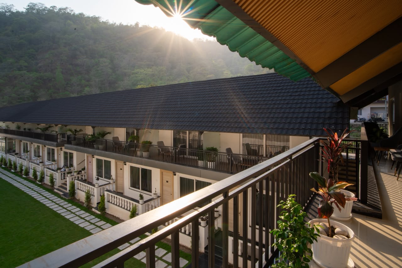 Morning sun over the forested hillside behind the room wing at Nature Nest Retreats