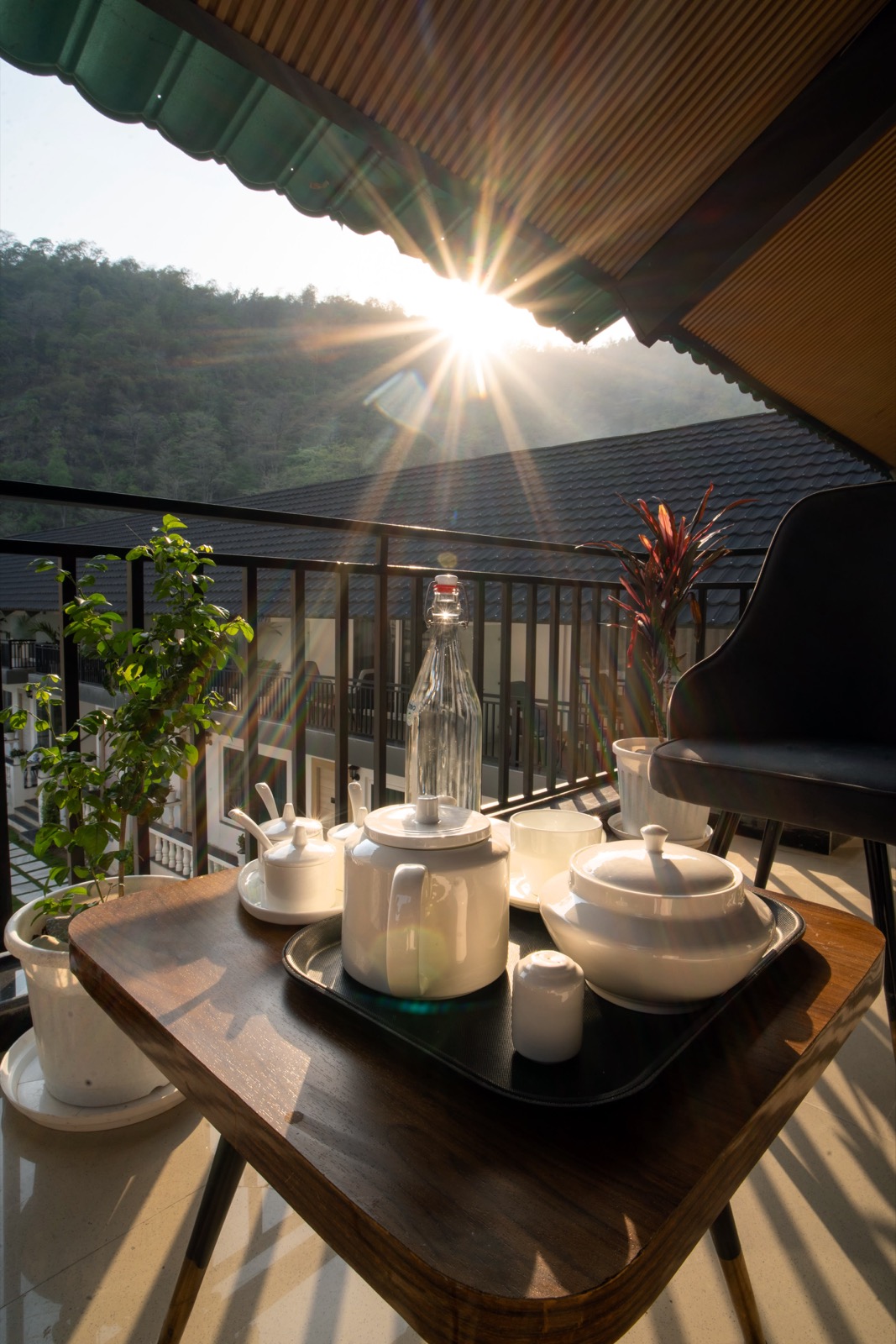 Tea tray on a balcony table as the sun sets behind the hills